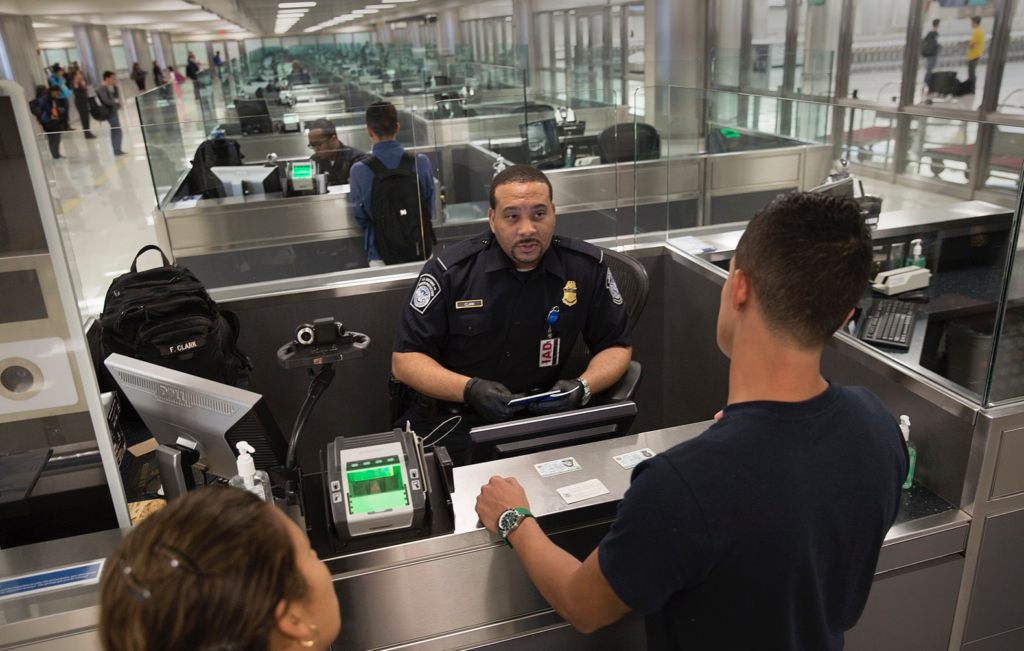 Un agent de la CBP passant en revue un couple de voyageurs
